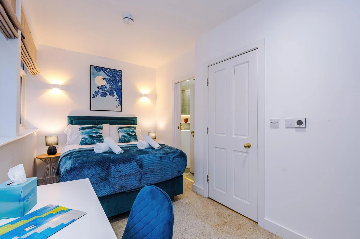 Hilltop serviced apartment bedroom with teal accent wall